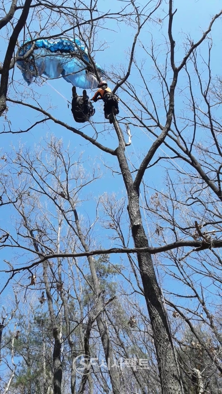 광명소방서 최의환구조대원이 패러글라이딩 사고로 인한 20미터 나무에 걸려 매달려 있는 요구조자에게 안전로프를 연결하고 있다. [사진=광명소방서]